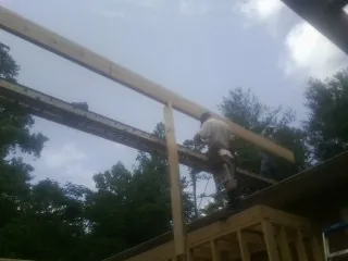 Carpenter setting a ridge beam over a new addition frame — Ice Dam Removal by Roofing Brothers in Saugerties