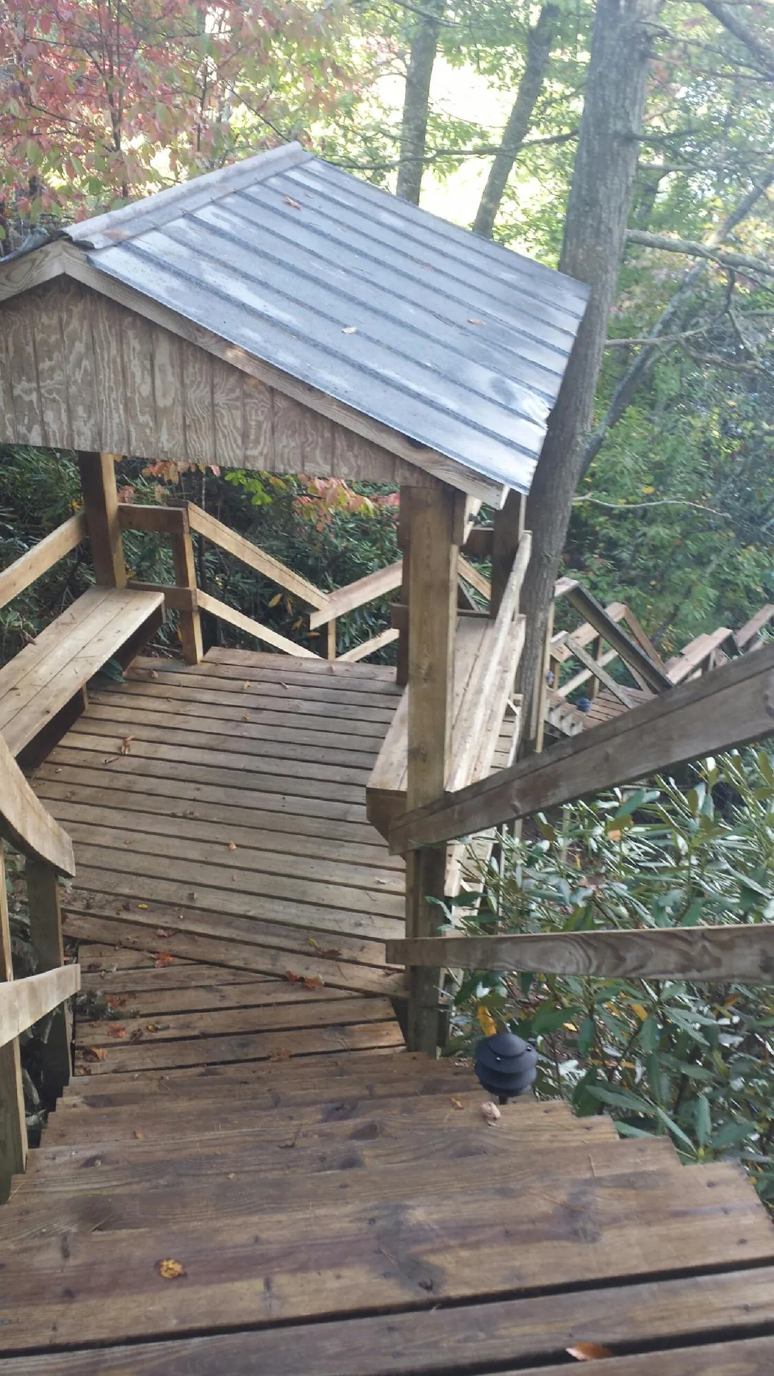 Metal roofed shelter over wooden steps on a wooded walkway — Skylight Repair & Installation work by our crew in Saugerties